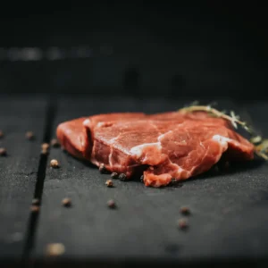 Beef tenderloin steak from Pure Valley Farms on slate with peppercorns and thyme
